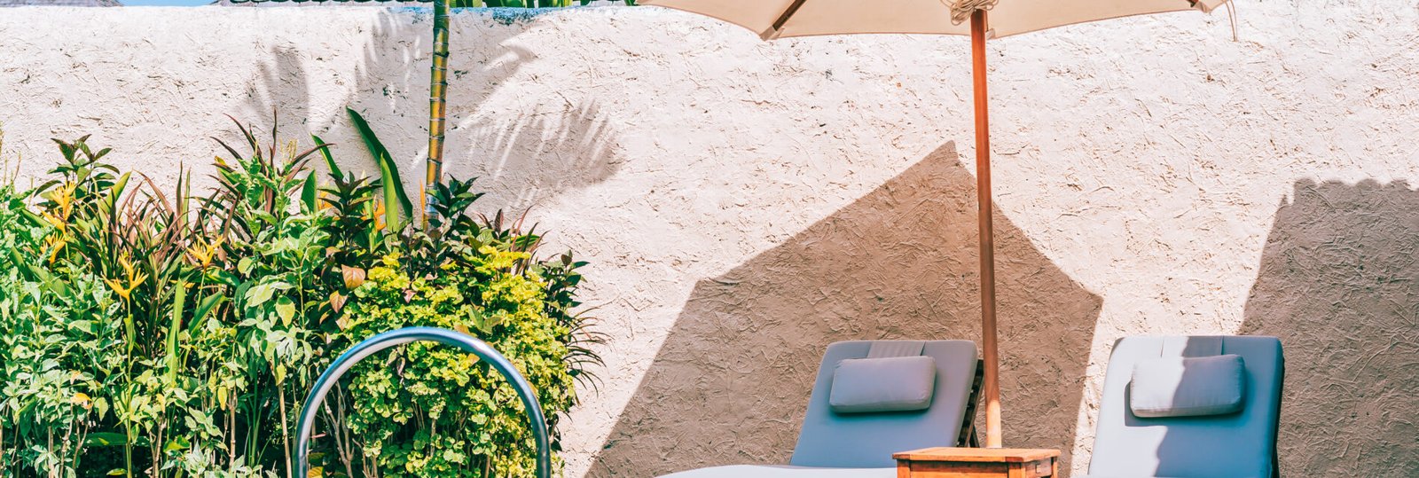 Umbrella and chair around swimming pool neary beautiful landscape of sea ocean beach with blue sky and white cloud for leisure travel and vacation