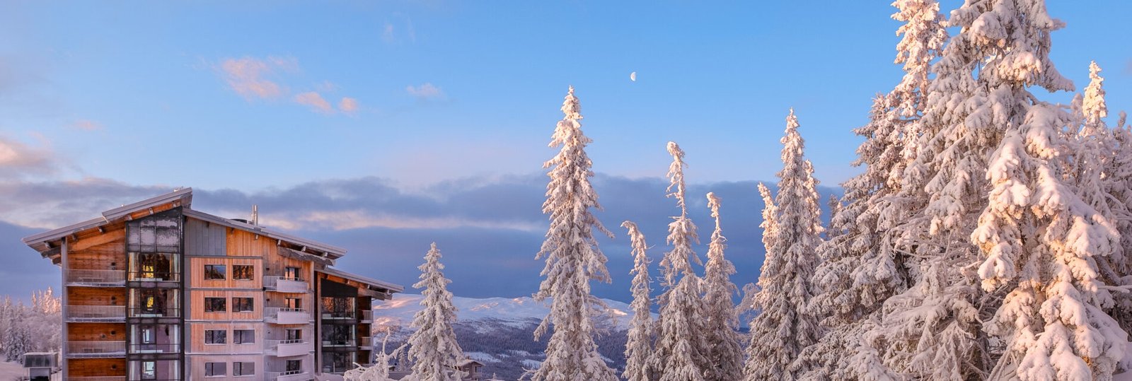 A beautiful shot of a residential building in a snow land on background of the blue sky